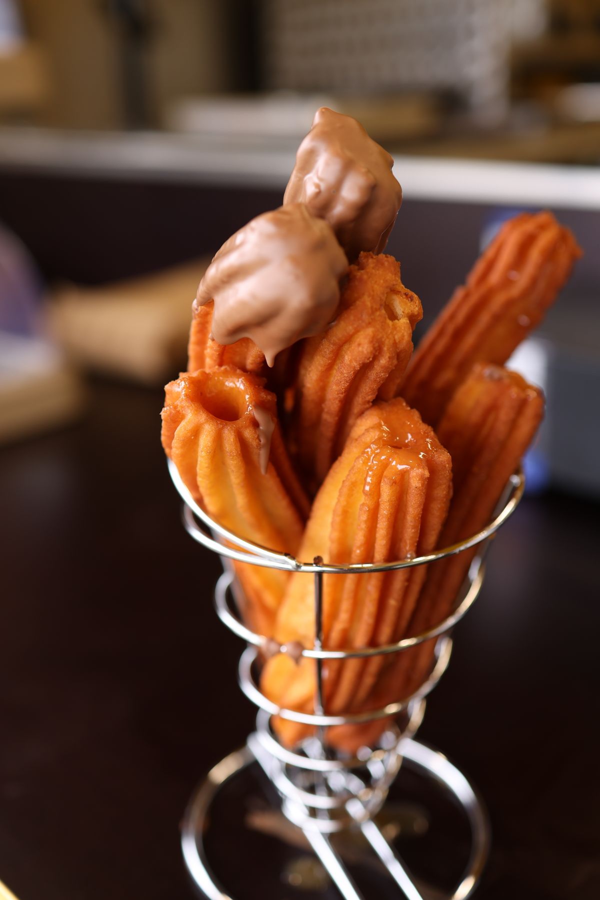 Basket of freshly made churros topped with chocolate