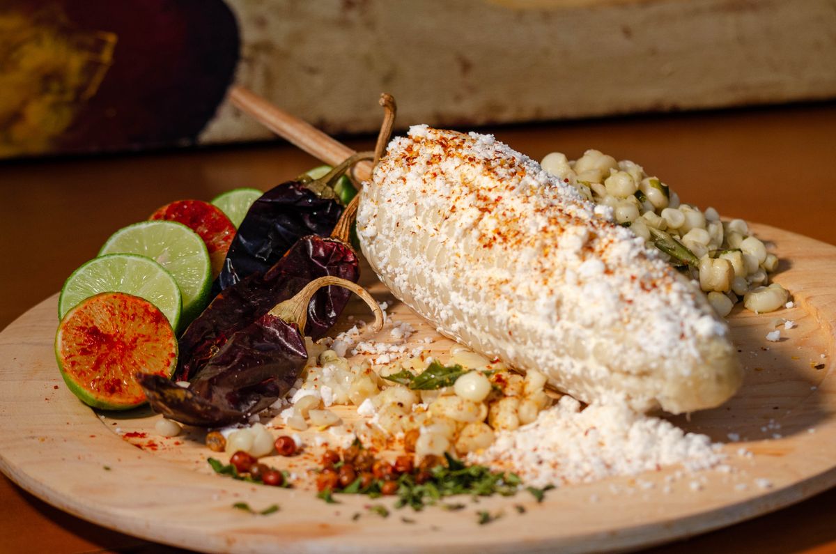 Elote street corn in a cup topped with chili, lime, and cheese