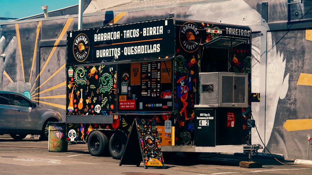 Vibrant Mexican food truck offering tacos and burritos in a lively urban environment